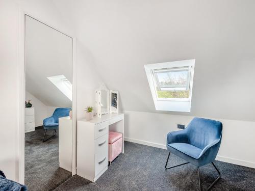 um quarto com uma cadeira azul e um espelho em Silvaplana em Canterbury