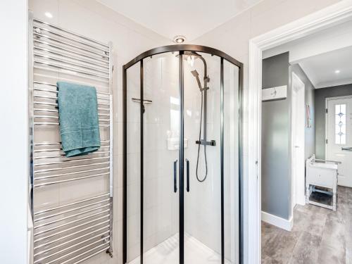 a shower with a glass door in a bathroom at Silvaplana in Canterbury