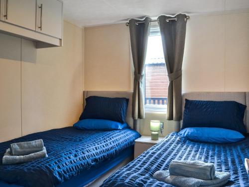1 dormitorio con 2 camas y ventana en Emilys Escape - Uk46722, en Bridlington