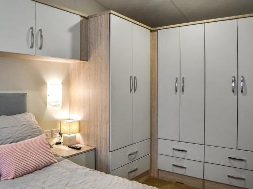 1 dormitorio con armarios blancos y 1 cama en Rosies Retreat - Uk46724 en Bridlington