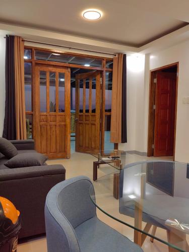 a living room with a glass table and a couch at Michael's Apartment in Moalboal