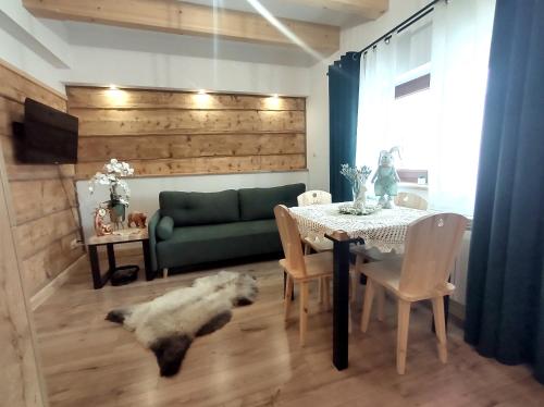 una sala de estar con una mesa y un perro tirado en el suelo en Apartamenty Przy Rynku Szaflary, en Szaflary
