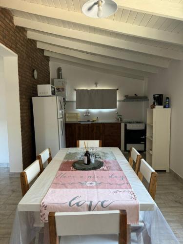 a kitchen with a table with chairs and a refrigerator at La Francesca-cabañas in Merlo