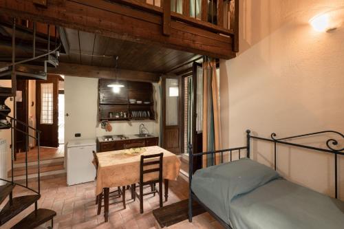 a bedroom with a bed and a table and a kitchen at Birrificio del Catria in Cantiano