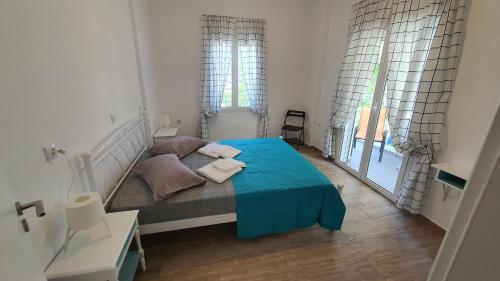 um quarto com uma cama com um cobertor azul em Angela's Luxury Apartments em Kamena Vourla