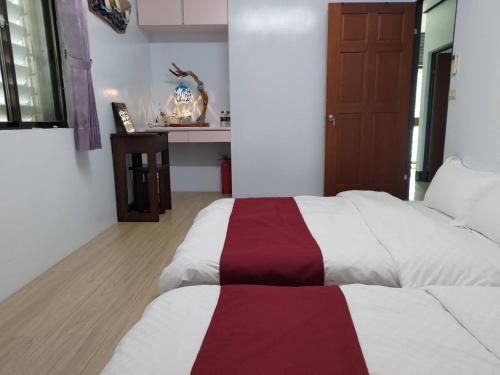 a bedroom with a bed with a red and white blanket at B&G Crafs Art House in Chenggong