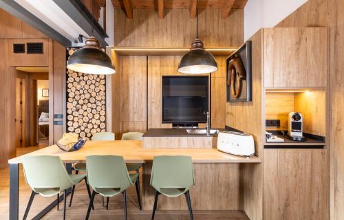 a kitchen with a large wooden table and chairs at Cases Cerdanya Mountain Residences in Bellver de Cerdanya 