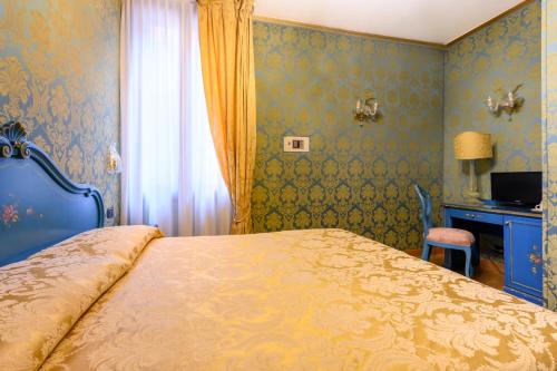 a bedroom with a bed and a desk and a window at Residenza Ca' San Marco in Venice