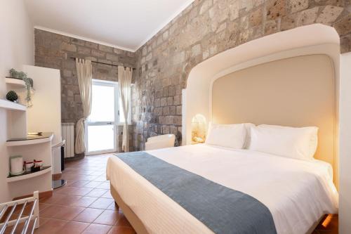 um quarto com uma cama grande e uma parede de pedra em Casale Antonietta em Sorrento