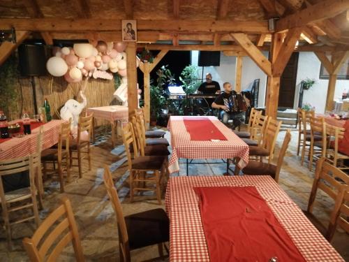 a restaurant with tables and chairs and people in the background at Etno selo Lelić in Valjevo