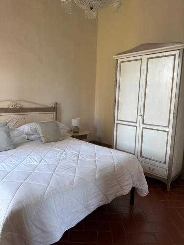 a bedroom with a large white bed and a chandelier at Castello Vicchiomaggio in Greve in Chianti