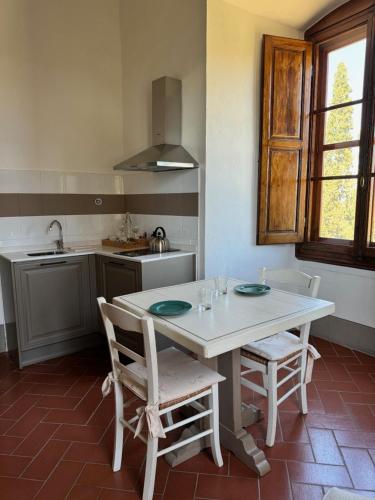 a kitchen with a white table and two chairs at Castello Vicchiomaggio in Greve in Chianti