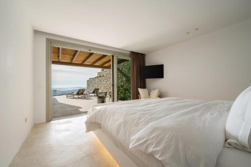 a bedroom with a bed and a view of the ocean at Mykonos Rocks Villas & Suites in Mikonos