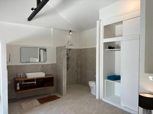 un bagno con un water, un lavandino e uno specchio di UMiiMAAN pool villa, 4BR, 4BA a Ko Samui