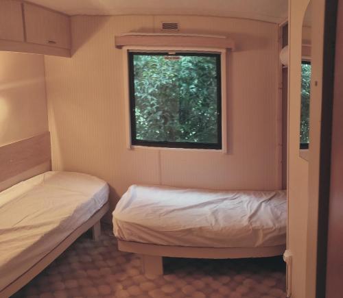 Un pat sau paturi într-o cameră la Camping du Hameau dé nousté temps