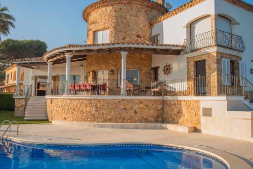 eine Villa mit einem Pool vor einem Haus in der Unterkunft COSTA BRAVA SUITES Villa Bonavida in Sant Feliu de Guixols