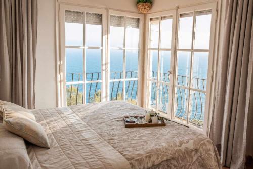a bedroom with a large bed and a large window at COSTA BRAVA SUITES Villa Bonavida in Sant Feliu de Guixols
