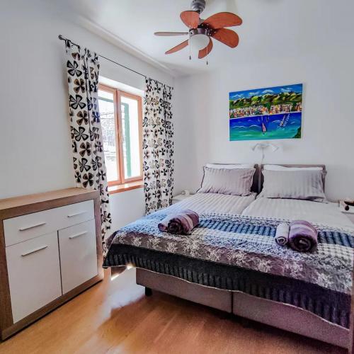 Schlafzimmer mit einem Bett und einem Deckenventilator in der Unterkunft Holiday Home Old Art in Kaštela