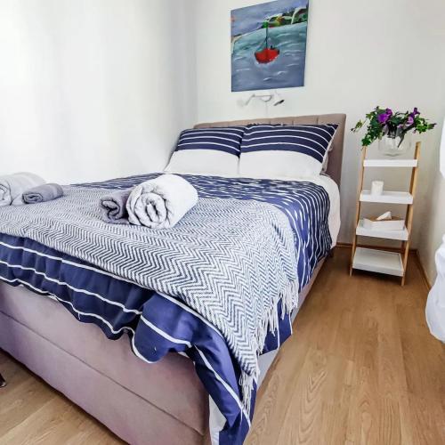 ein Schlafzimmer mit einem Bett mit einer blauen und weißen Decke in der Unterkunft Holiday Home Old Art in Kaštela