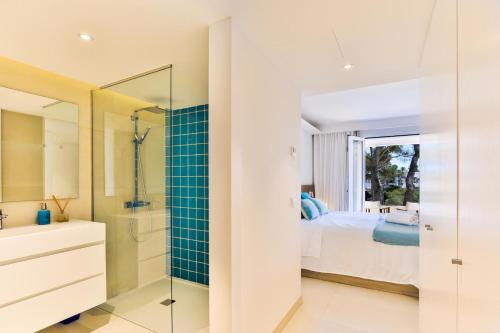 a bathroom with a shower and a bedroom with a bed at Vista DOr in Cala d´Or