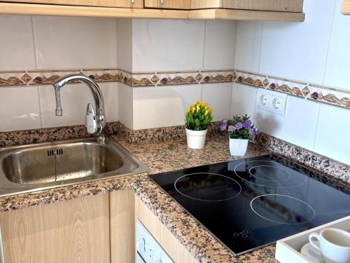 a kitchen with a sink and a stove at APARTBEACH ARRECIFE y FRENTE PLAYA in La Pineda