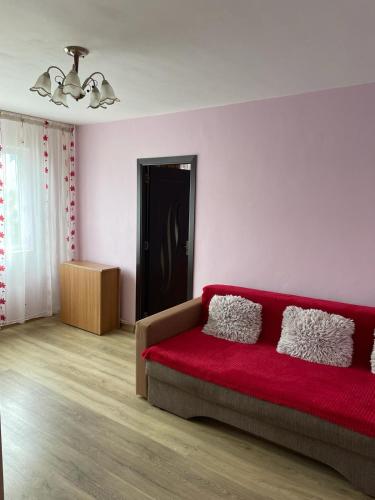 a living room with a red couch in a room at Cozy Apartment in Bacău