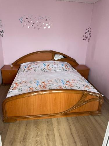 ein Bett in einem Schlafzimmer mit einem Bettrahmen aus Holz in der Unterkunft Cozy Apartment in Bacău
