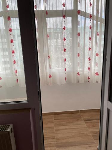 a room with a window with white curtains at Cozy Apartment in Bacău