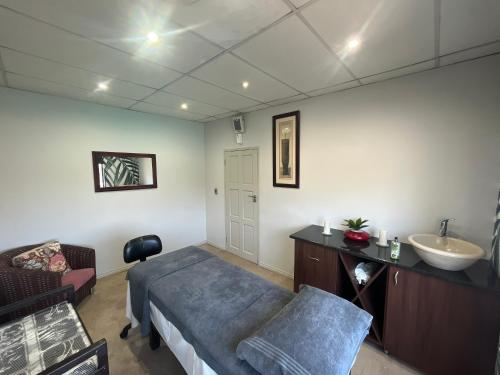 フェリーニヒングにあるRiviera on Vaal Resortのベッド、シンク、ソファが備わる客室です。