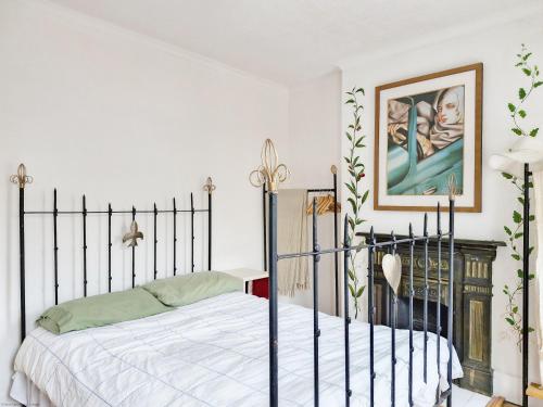 a bedroom with a bed and a painting on the wall at Tern Cottage in Bognor Regis