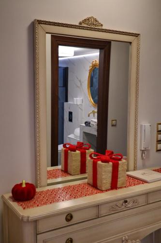 a mirror on top of a dresser with gift boxes at Vip Lepanto Castle Suites in Nafpaktos