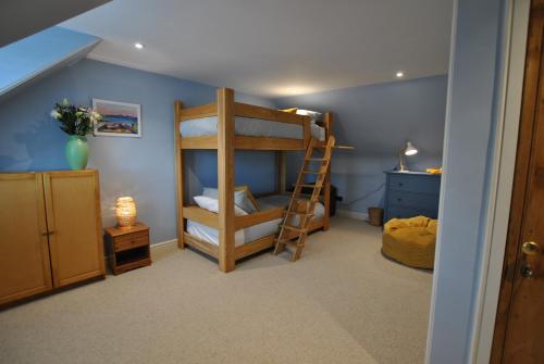 a room with a bunk bed and a ladder at The House on the Square- Coastal Townhouse in Saint Monance