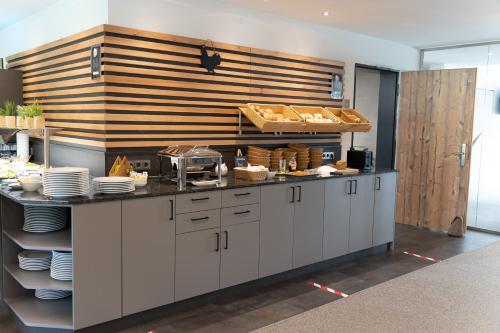 a kitchen with a counter with plates and dishes at Hotel Grohnder Fährhaus in Emmerthal