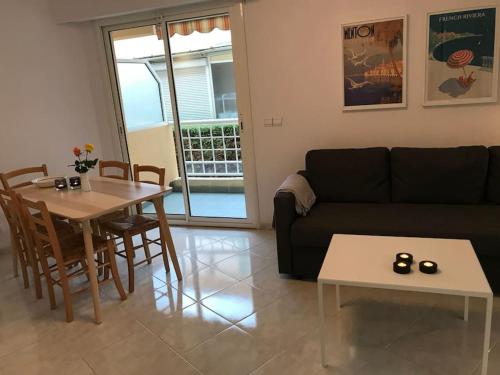 uma sala de estar com um sofá preto e uma mesa em Holiday rental in Roquebrune Cap Martin em Roquebrune-Cap-Martin