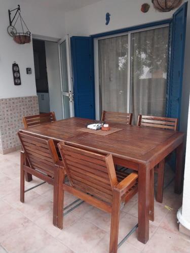 a wooden table with four wooden chairs around it at Kings Apartment with private Garden in Paphos City