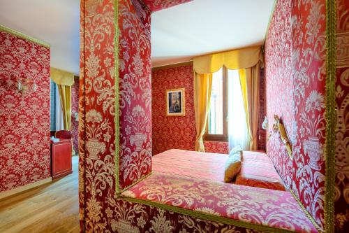 a bedroom with red walls and a bed with a bench at Residenza Ca' San Marco in Venice