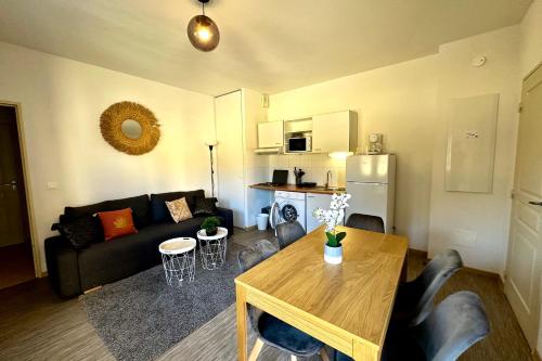 a living room with a couch and a table at Les Naïades D15- 2 bedrooms for 5 people ! in Avène