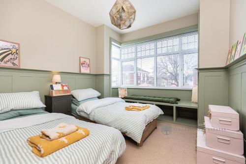 um quarto com 2 camas e uma janela em Luxury Christchurch Retreat em Iford