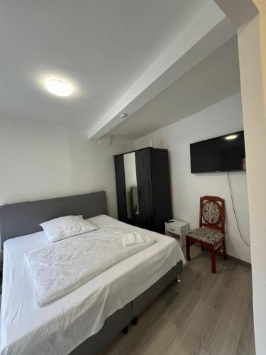una camera con un letto bianco e una sedia di Ferienwohnung ENJOY 2 a Goslar