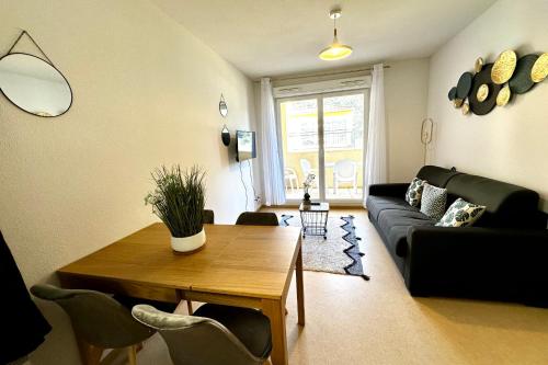 a living room with a table and a couch at Les Naïades E20 - 2 bedrooms for 5 people ! in Avène