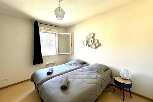 E20 Les Naïades- 2 bedrooms for 5 people ! في أفين: غرفة نوم عليها سرير وحذائين