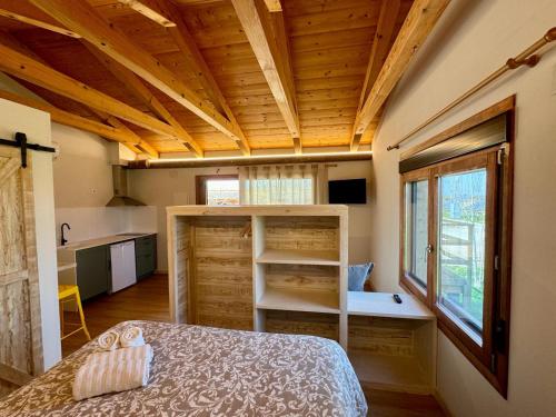 una camera con letto in una stanza con soffitti in legno di Alojamiento Rural La Alberca ad Arguedas