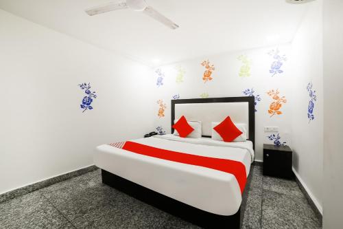 a bedroom with a large bed with red pillows at OYO My Comfortable Hotel in New Delhi