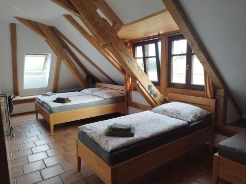 1 dormitorio con 2 camas en un ático en Penzion a hostinec Na Návsi, en Nová Bystřice