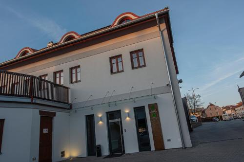 um edifício branco com uma varanda numa rua em Hotel Grunt em Mladá Boleslav