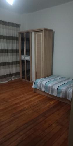a bedroom with a bed and a wooden floor at Homex RT in Alexandria