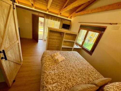 アルゲダスにあるAlojamiento Rural La Albercaのベッドルーム1室(ベッド1台付)、大きな木製ドアが備わります。
