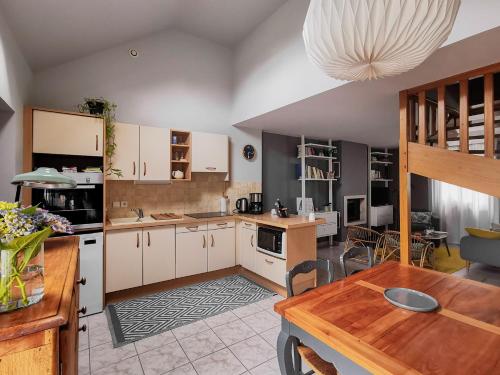 une cuisine avec des armoires blanches et une table en bois dans l'établissement Sainte Marine, à Sainte-Marine