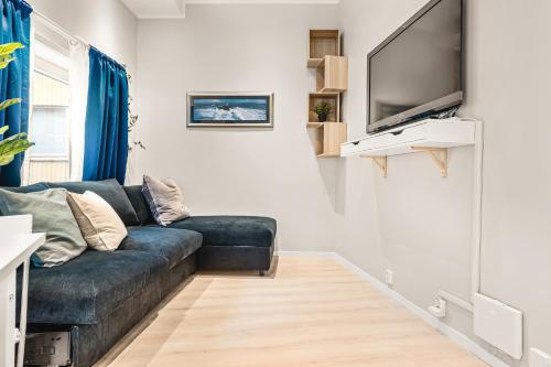 een woonkamer met een bank en een flatscreen-tv bij Dinbnb Apartments I Apartment Hotel at City Centre with Roof Terrace in Bergen