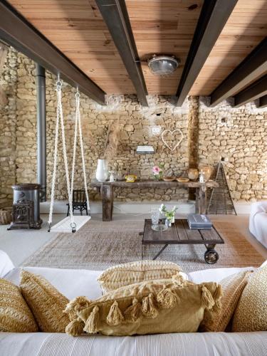 une chambre avec un lit pivotant et un mur en pierre dans l'établissement Bassiviere Barn Chic, à Saint-Étienne-de-Villeréal